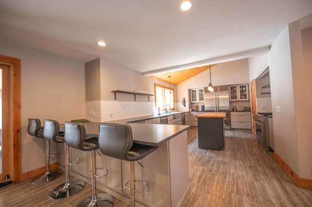 15 Spring Hill Rd, Dover, VT 05356 - kitchen featuring high quality appliances, lofted ceiling, tasteful backsplash, a peninsula, and a center island