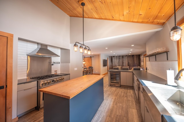 15 Spring Hill Rd, Dover, VT 05356 - kitchen with butcher block counters, wall chimney range hood, wine cooler, high end stainless steel range, and decorative backsplash
