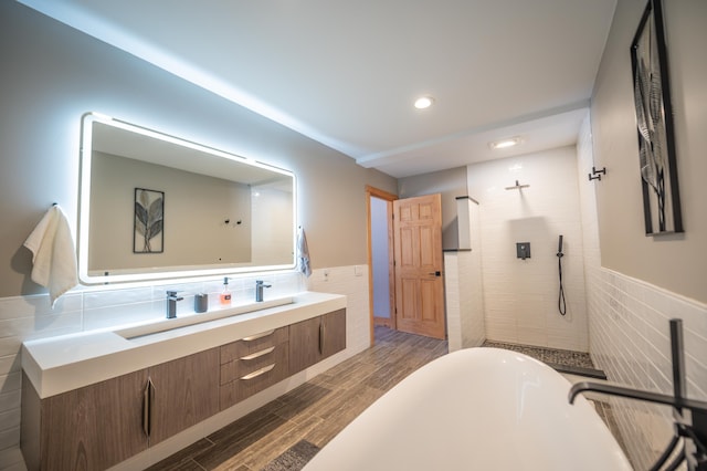 15 Spring Hill Rd, Dover, VT 05356 - bathroom with tile walls, wood finished floors, a freestanding tub, wainscoting, and a tile shower