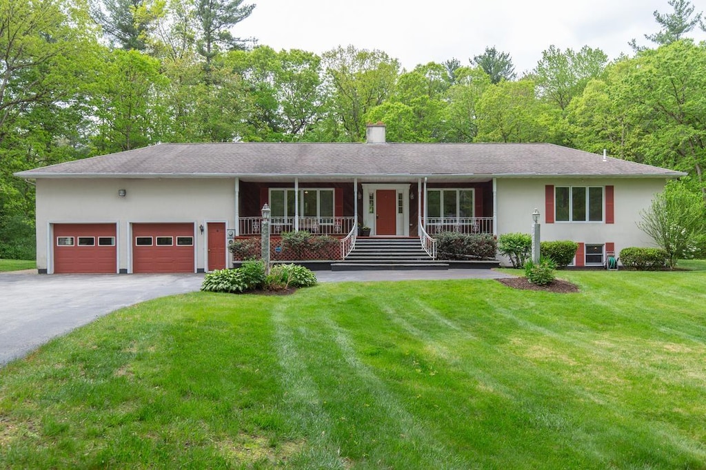 23 Winslow Farm Rd, Hudson, NH 03051 - ranch-style house featuring covered porch, a garage, a front yard, driveway, and stucco siding