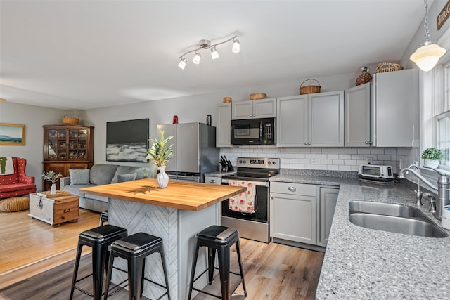 312 Browns Trce, Jericho, VT 05465 - kitchen featuring stainless steel appliances, a sink, butcher block counters, a kitchen bar, and light wood-type flooring