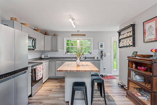 312 Browns Trce, Jericho, VT 05465 - kitchen featuring stainless steel appliances, wooden counters, a breakfast bar area, backsplash, and light wood finished floors