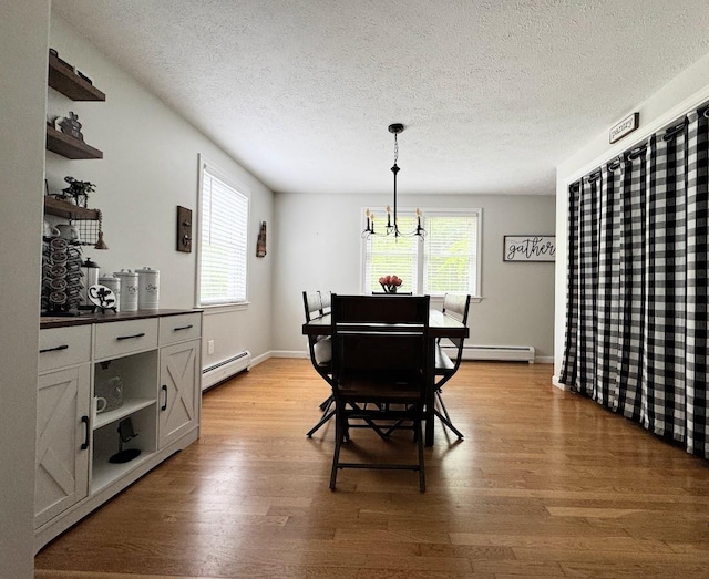 10 Irving Dr, Weare, NH 03281 - dining area with baseboard heating, light wood finished floors, a textured ceiling, and a chandelier
