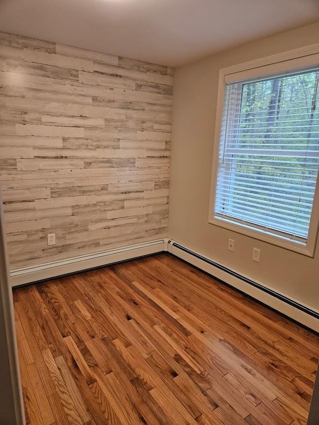 10 Irving Dr, Weare, NH 03281 - spare room featuring baseboard heating, wooden walls, and wood finished floors