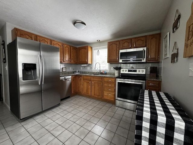 10 Irving Dr, Weare, NH 03281 - kitchen featuring stainless steel appliances, tasteful backsplash, a sink, light tile patterned floors, and a textured ceiling