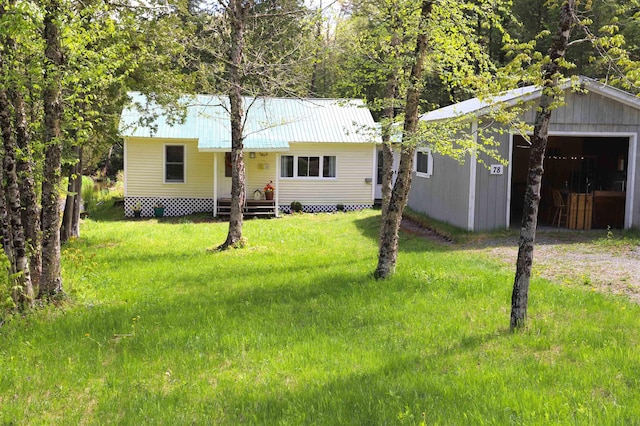 78 Daniels Pond Rd, Glover, VT 05839 - view of front of house featuring driveway, metal roof, a front yard, a garage, and an outbuilding
