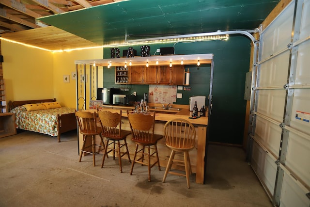 78 Daniels Pond Rd, Glover, VT 05839 - kitchen with a sink, a kitchen bar, a peninsula, and brown cabinetry