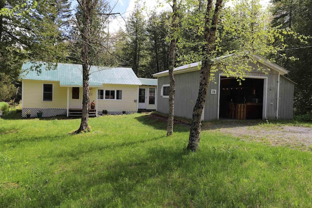 78 Daniels Pond Rd, Glover, VT 05839 - view of front of property featuring driveway, a detached garage, an outbuilding, a front yard, and metal roof