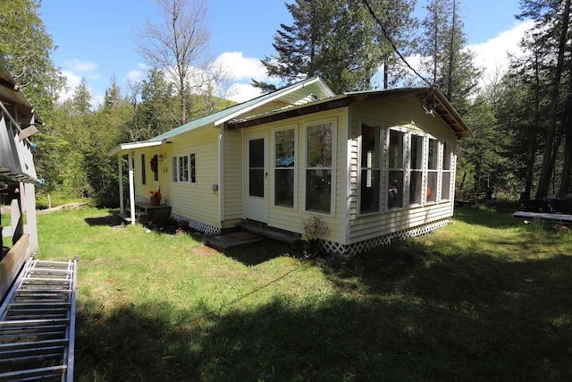 78 Daniels Pond Rd, Glover, VT 05839 - view of side of home with entry steps, a lawn, metal roof, and a sunroom
