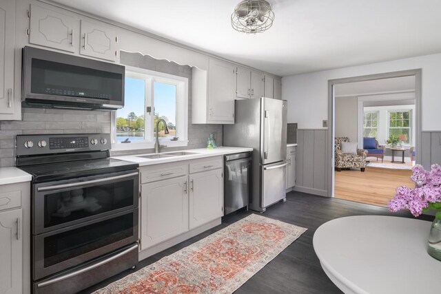 354 Dover Point Rd, Dover, NH 03820 - kitchen featuring stainless steel appliances, a sink, backsplash, light countertops, and dark wood finished floors