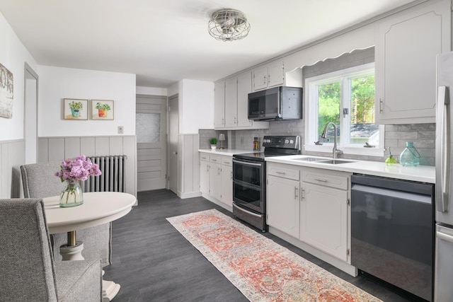 354 Dover Point Rd, Dover, NH 03820 - kitchen with appliances with stainless steel finishes, radiator, a sink, light countertops, and wainscoting
