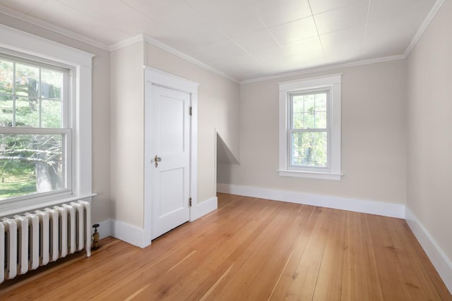 354 Dover Point Rd, Dover, NH 03820 - empty room with radiator heating unit, light wood-type flooring, baseboards, and ornamental molding