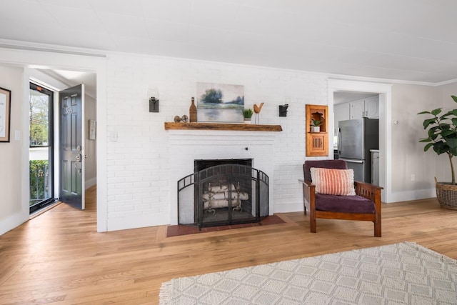 354 Dover Point Rd, Dover, NH 03820 - living room with wood finished floors, a brick fireplace, and baseboards