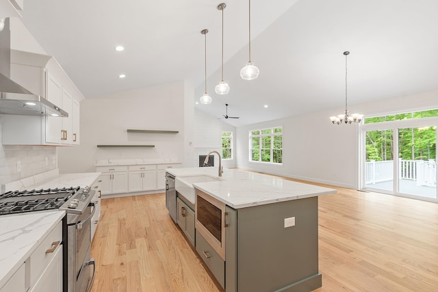 380 Greenfield Rd, Peterborough, NH 03458 - kitchen with appliances with stainless steel finishes, a sink, wall chimney range hood, open shelves, and light wood-style floors