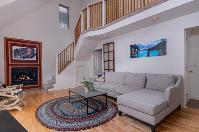 31 Plumley Ave, Ludlow, VT 05149 - living area with a towering ceiling, stairway, wood finished floors, a fireplace with flush hearth, and baseboards