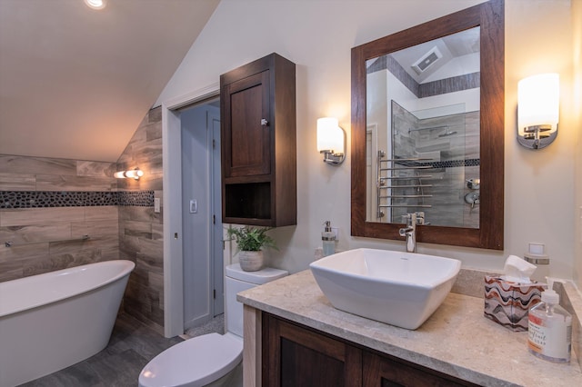 31 Plumley Ave, Ludlow, VT 05149 - bathroom with vaulted ceiling, a freestanding tub, vanity, toilet, and tile walls