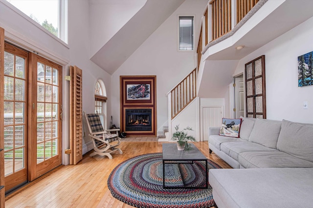 31 Plumley Ave, Ludlow, VT 05149 - living room featuring a towering ceiling, hardwood / wood-style flooring, and a glass covered fireplace