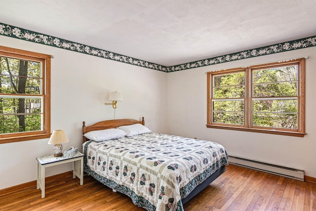 133 Pine Meadow Dr, Colchester, VT 05446 - bedroom with a baseboard radiator, hardwood / wood-style flooring, and baseboards