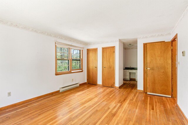 133 Pine Meadow Dr, Colchester, VT 05446 - unfurnished bedroom featuring a baseboard heating unit, light wood finished floors, multiple closets, and baseboards