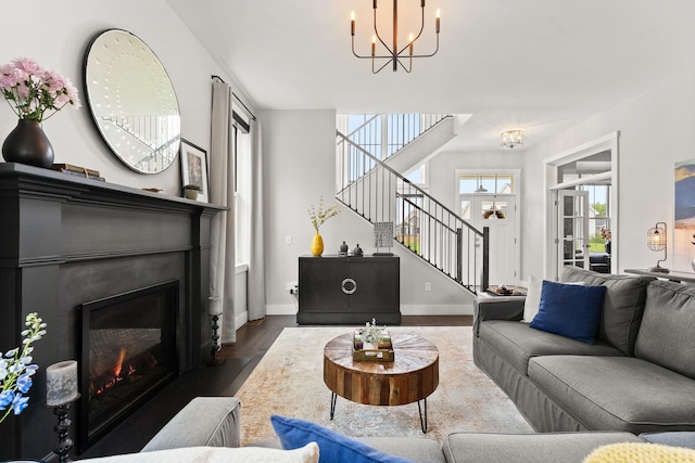 36 Caspian Ln, Shelburne, VT 05482 - living room featuring stairs, a chandelier, dark wood-type flooring, a fireplace with flush hearth, and baseboards
