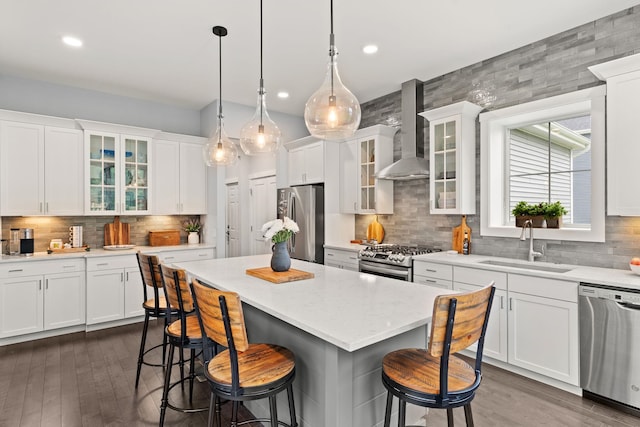 36 Caspian Ln, Shelburne, VT 05482 - kitchen featuring stainless steel appliances, wall chimney exhaust hood, a sink, a kitchen bar, and backsplash