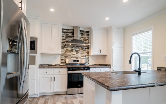26 Deerfield Ct, Rochester, NH 03868 - kitchen featuring stainless steel appliances, wall chimney exhaust hood, dark countertops, a sink, and light wood-style floors