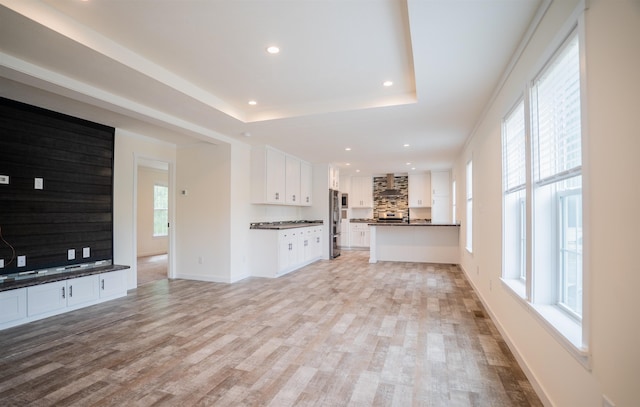 26 Deerfield Ct, Rochester, NH 03868 - unfurnished living room with light wood-style flooring, recessed lighting, a tray ceiling, and baseboards