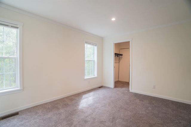26 Deerfield Ct, Rochester, NH 03868 - unfurnished bedroom with ornamental molding, multiple windows, carpet, baseboards, and a walk in closet
