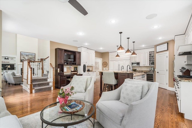 72 Settlers Ct, Bedford, NH 03110 - living area featuring stairway, ceiling fan, recessed lighting, wood finished floors, and beverage cooler