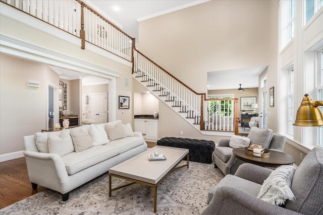 72 Settlers Ct, Bedford, NH 03110 - living room with stairs, a high ceiling, wood finished floors, baseboards, and a ceiling fan