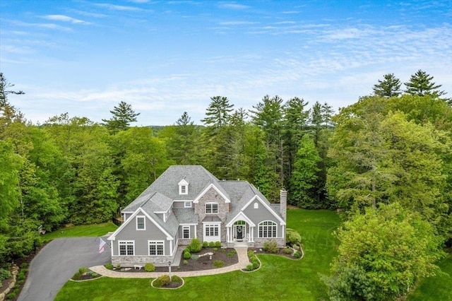72 Settlers Ct, Bedford, NH 03110 - view of front of house with a wooded view, a front yard, a chimney, and a porch