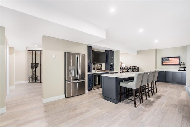 72 Settlers Ct, Bedford, NH 03110 - kitchen with stainless steel fridge, light countertops, wine cooler, light wood finished floors, and a breakfast bar area
