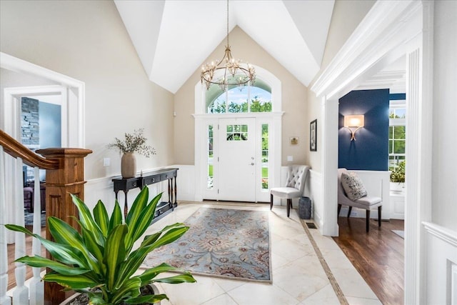 72 Settlers Ct, Bedford, NH 03110 - entryway with a chandelier, wainscoting, inlaid floor details, and high vaulted ceiling