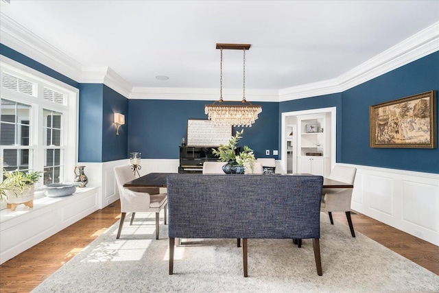 72 Settlers Ct, Bedford, NH 03110 - dining room featuring wainscoting, crown molding, wood finished floors, a decorative wall, and healthy amount of natural light