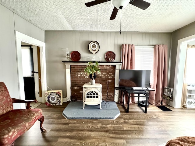 15 Park St, Colebrook, NH 03576 - living area featuring wood finished floors, a ceiling fan, and a wood stove