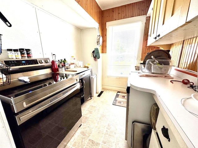 15 Park St, Colebrook, NH 03576 - kitchen with stainless steel electric range, light countertops, and wooden walls