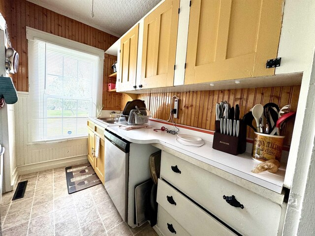 15 Park St, Colebrook, NH 03576 - kitchen featuring light countertops, wooden walls, dishwasher, open shelves, and a sink