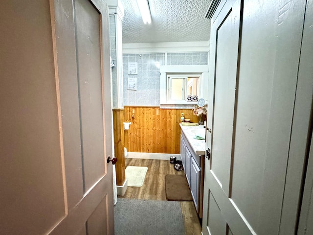 15 Park St, Colebrook, NH 03576 - bathroom featuring wooden walls, wood finished floors, and vanity