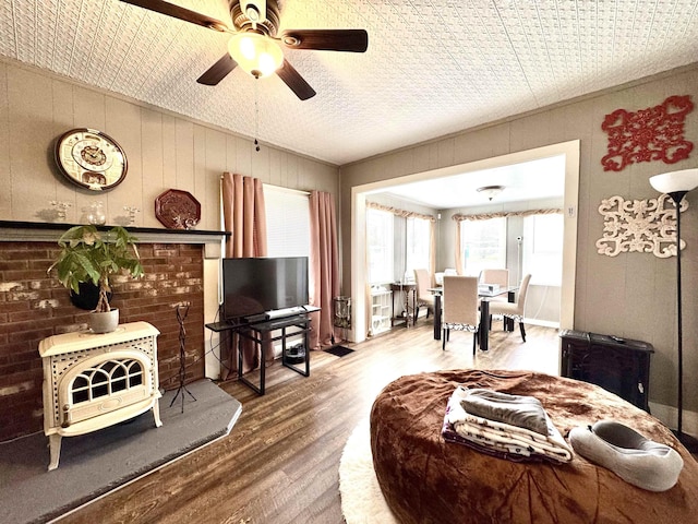 15 Park St, Colebrook, NH 03576 - living room featuring wood finished floors, a wood stove, and a ceiling fan