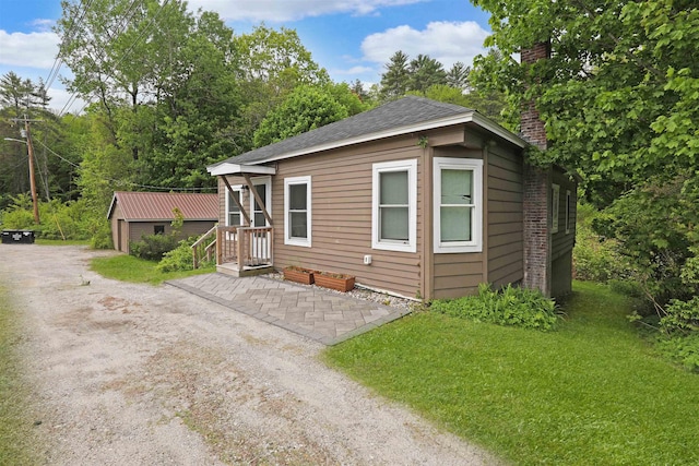20 Daniel Webster Hwy, Plymouth, NH 03264 - view of front of house with a chimney, an outdoor structure, and a shingled roof