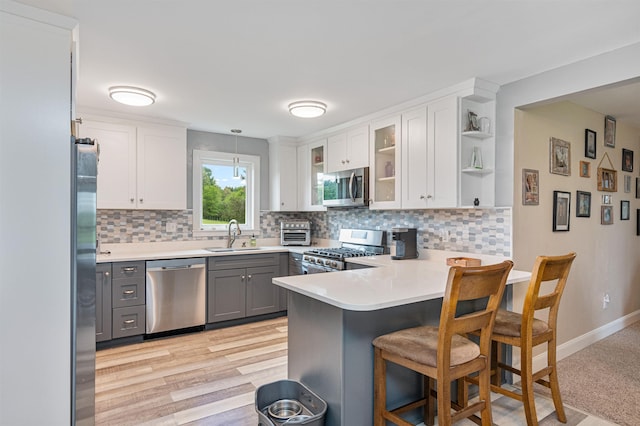 870 Cheesefactory Rd, Shelburne, VT 05482 - kitchen featuring appliances with stainless steel finishes, a peninsula, backsplash, a sink, and light countertops