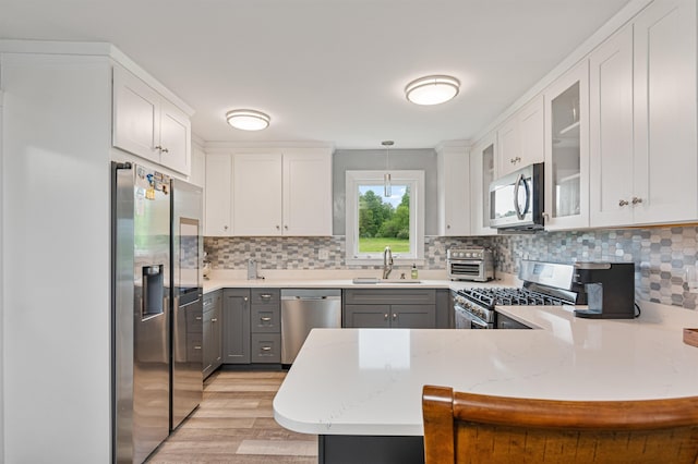 870 Cheesefactory Rd, Shelburne, VT 05482 - kitchen featuring stainless steel appliances, a sink, a peninsula, light wood finished floors, and gray cabinetry