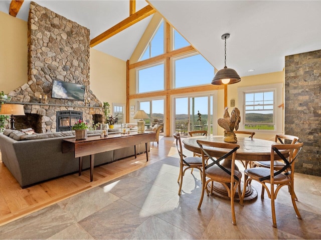 344 Morrie Rd, Washington, VT 05675 - dining space with a stone fireplace, beamed ceiling, high vaulted ceiling, and light tile patterned floors