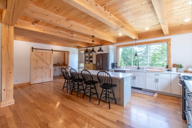 51 Lake View Rd, Westmore, VT 05822 - kitchen with appliances with stainless steel finishes, a barn door, wooden ceiling with exposed beams, a sink, and light wood finished floors