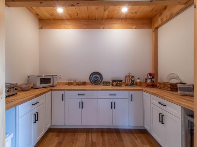 51 Lake View Rd, Westmore, VT 05822 - kitchen with wooden counters, white microwave, wine cooler, wood ceiling, and light wood-type flooring