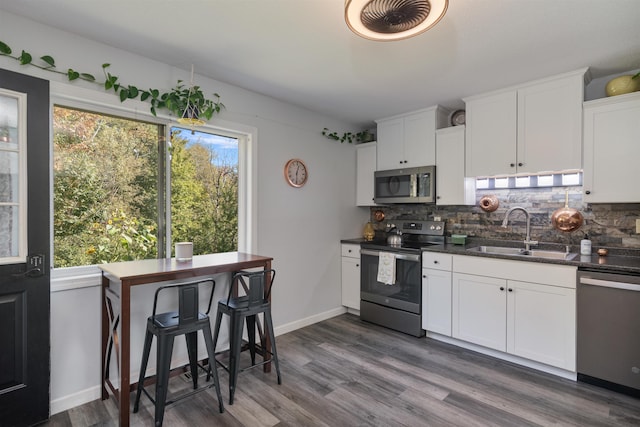 71 Scottsdale Rd, Newport City, VT 05855 - kitchen with stainless steel appliances, a sink, tasteful backsplash, white cabinets, and dark wood-type flooring