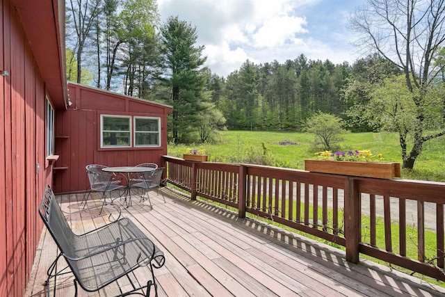 1176 Cross Rd, Strafford, VT 05070 - wooden deck featuring outdoor dining area, a lawn, and a view of trees