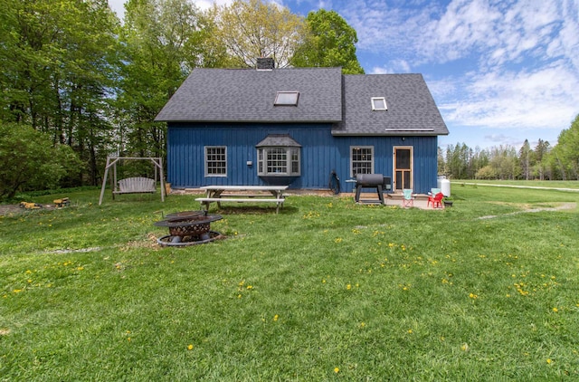 174 Andrews Rd, Holland, VT 05830 - back of house featuring an outdoor fire pit, a shingled roof, a chimney, a yard, and board and batten siding