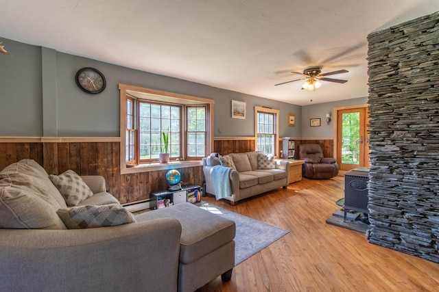 174 Andrews Rd, Holland, VT 05830 - living area with a wainscoted wall, wood finished floors, baseboard heating, ceiling fan, and wooden walls