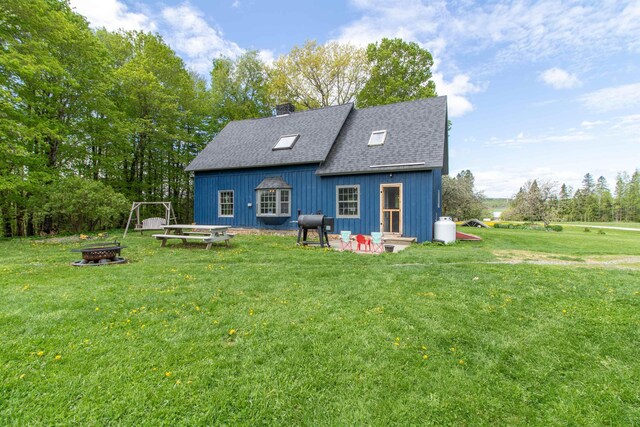 174 Andrews Rd, Holland, VT 05830 - back of house with an outdoor fire pit, a lawn, a chimney, and a shingled roof